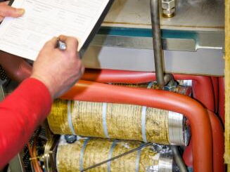 Servicetechniker dokumentiert Wartung, Service, Reparatur und Instandhaltung eines Temperiergeräts während des Serviceeinsatzes bei FIMRO